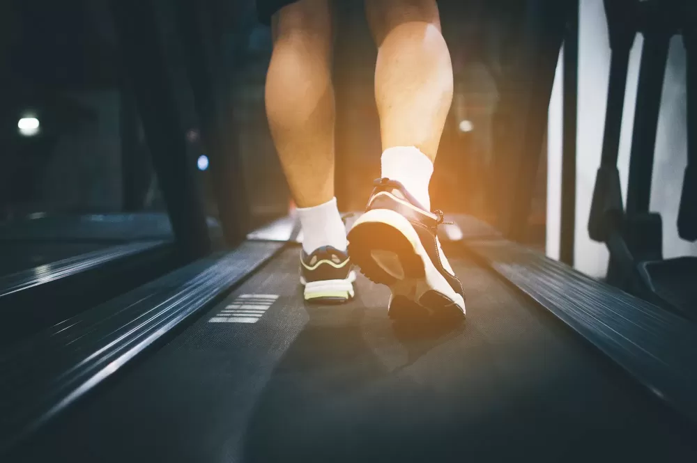 دانلود عکس یک مرد در حال راه رفتن روی تردمیل